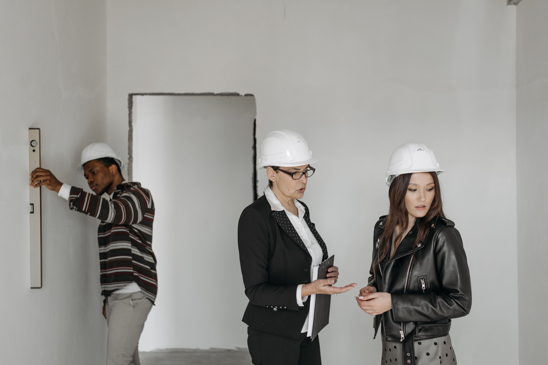 A broker walking clients through a property under renovation